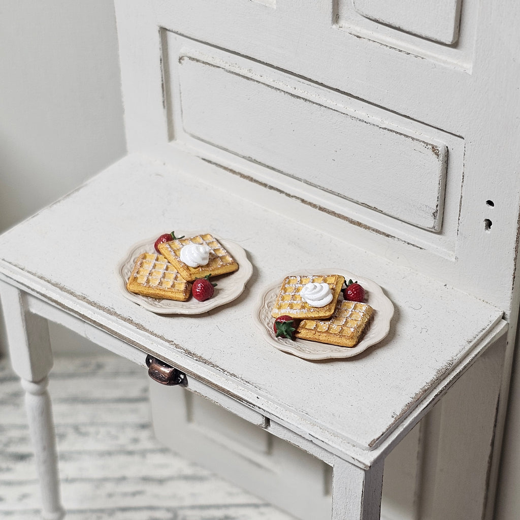 Teller mit Waffeln, Sahne und Erdbeeren