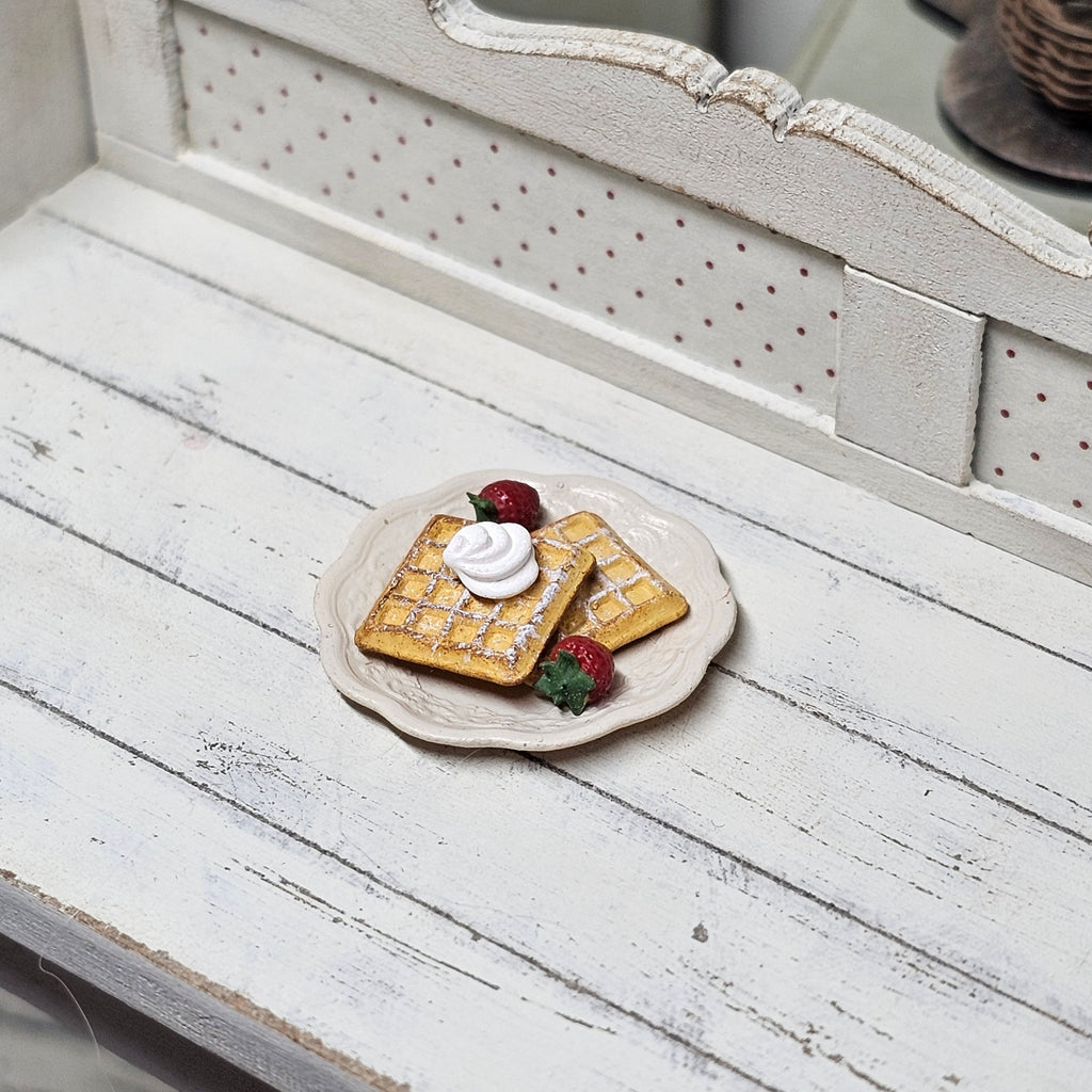 Teller mit Waffeln, Sahne und Erdbeeren